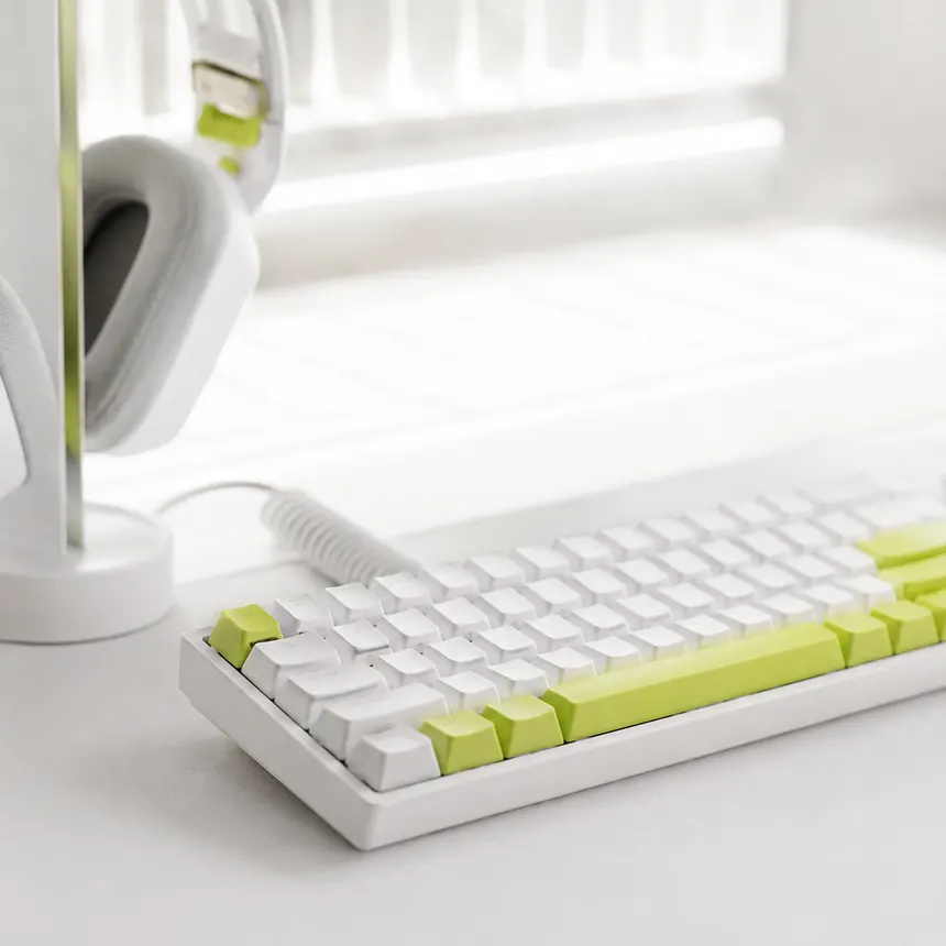 Teclado y audífonos con detalles en vólt sobre el escritorio
